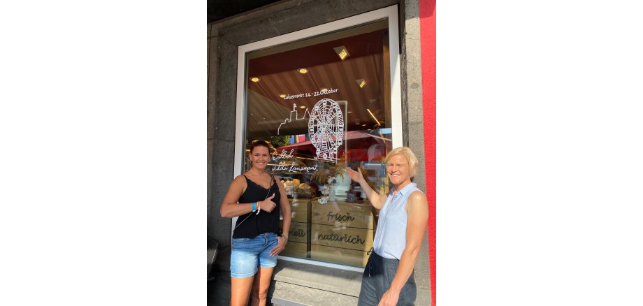 Tina Ixfeld (li.) und Kerstin Stüwe von der Wirtschaftsförderung freuen sich über die Dekoration der Schaufenster Zwei Personen vor dem Schaufenster