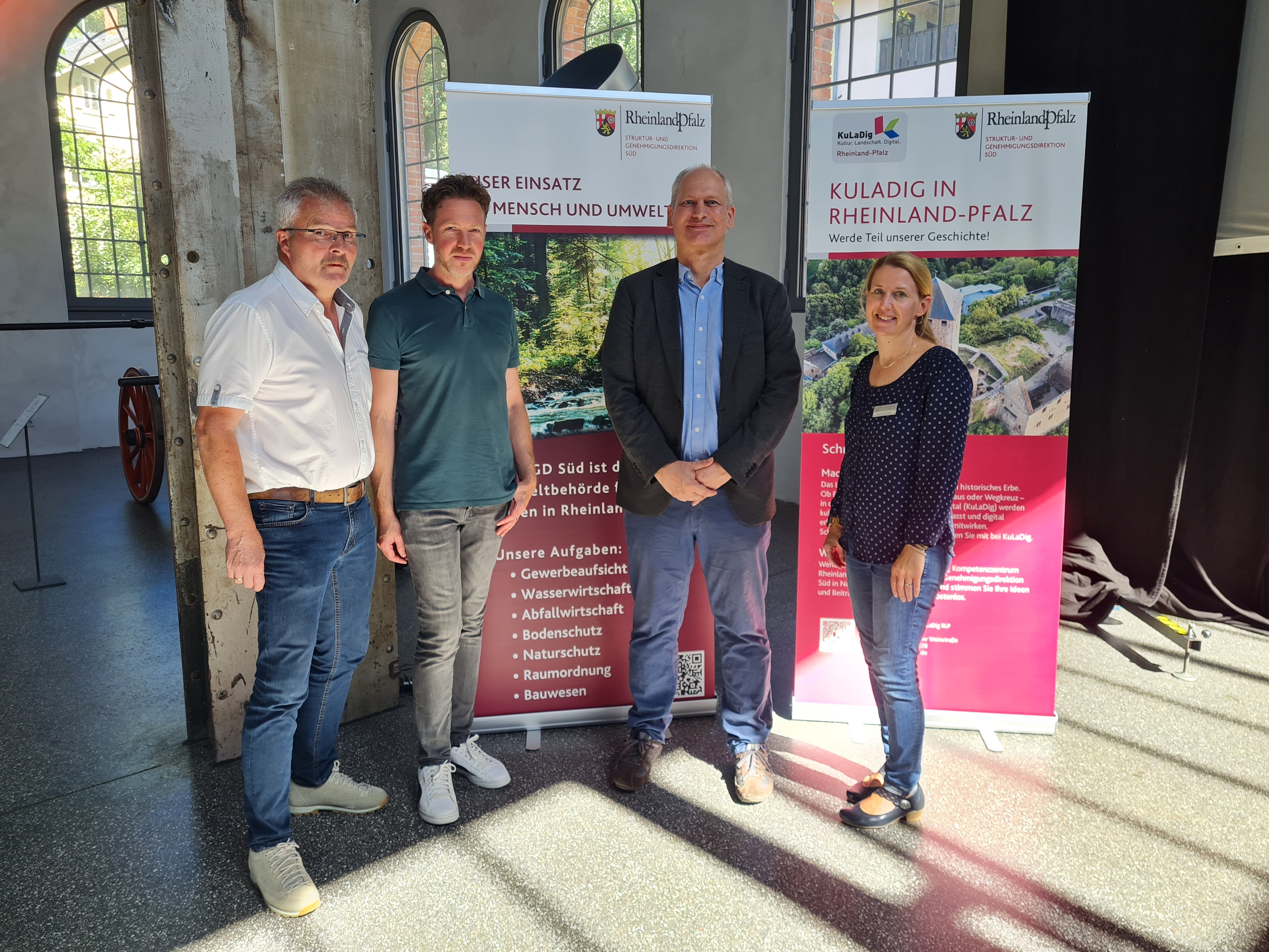 Vier Personen vor Werbe-Roll-Ups