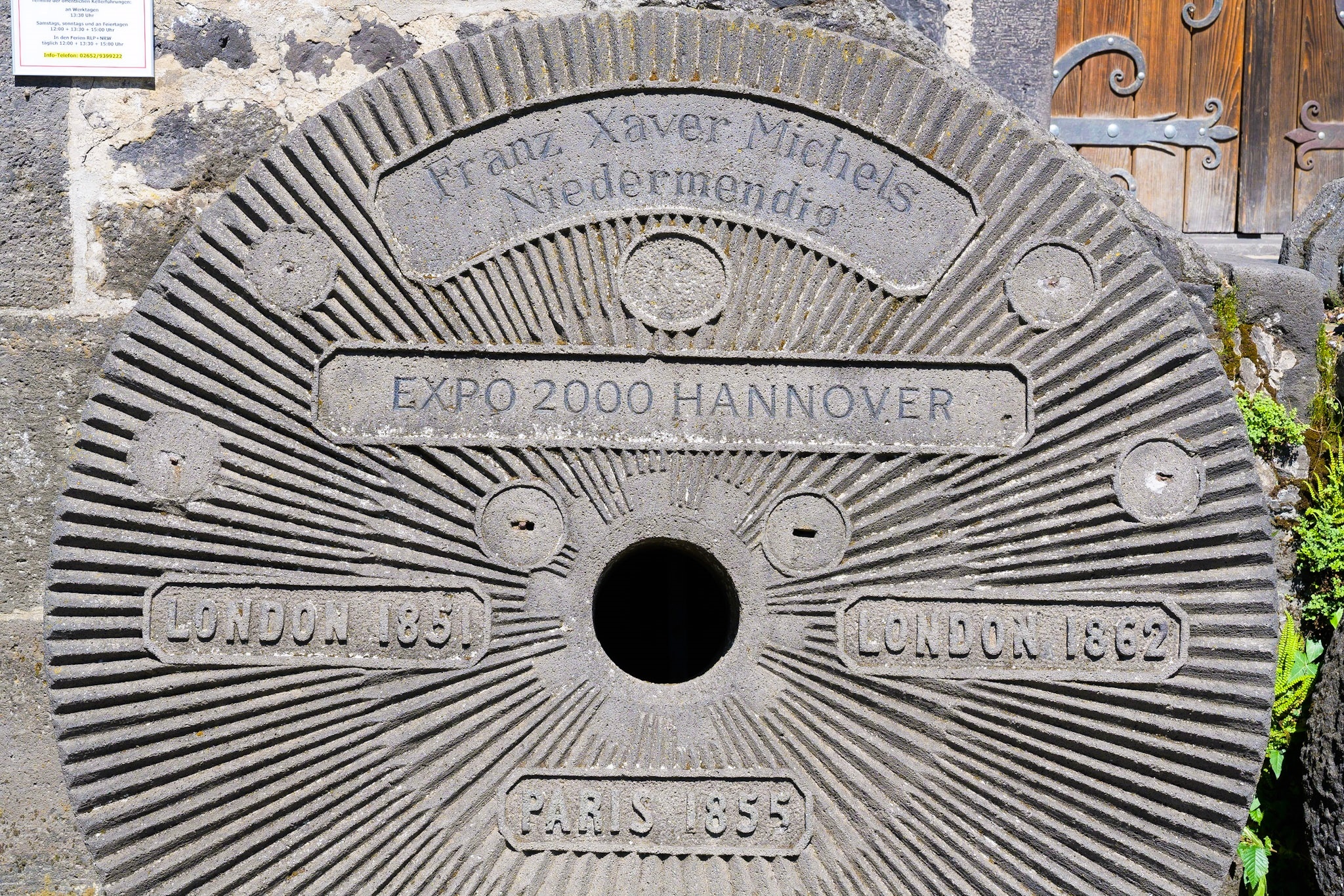 Mühlstein mit verschiedenen Aufschriften drauf