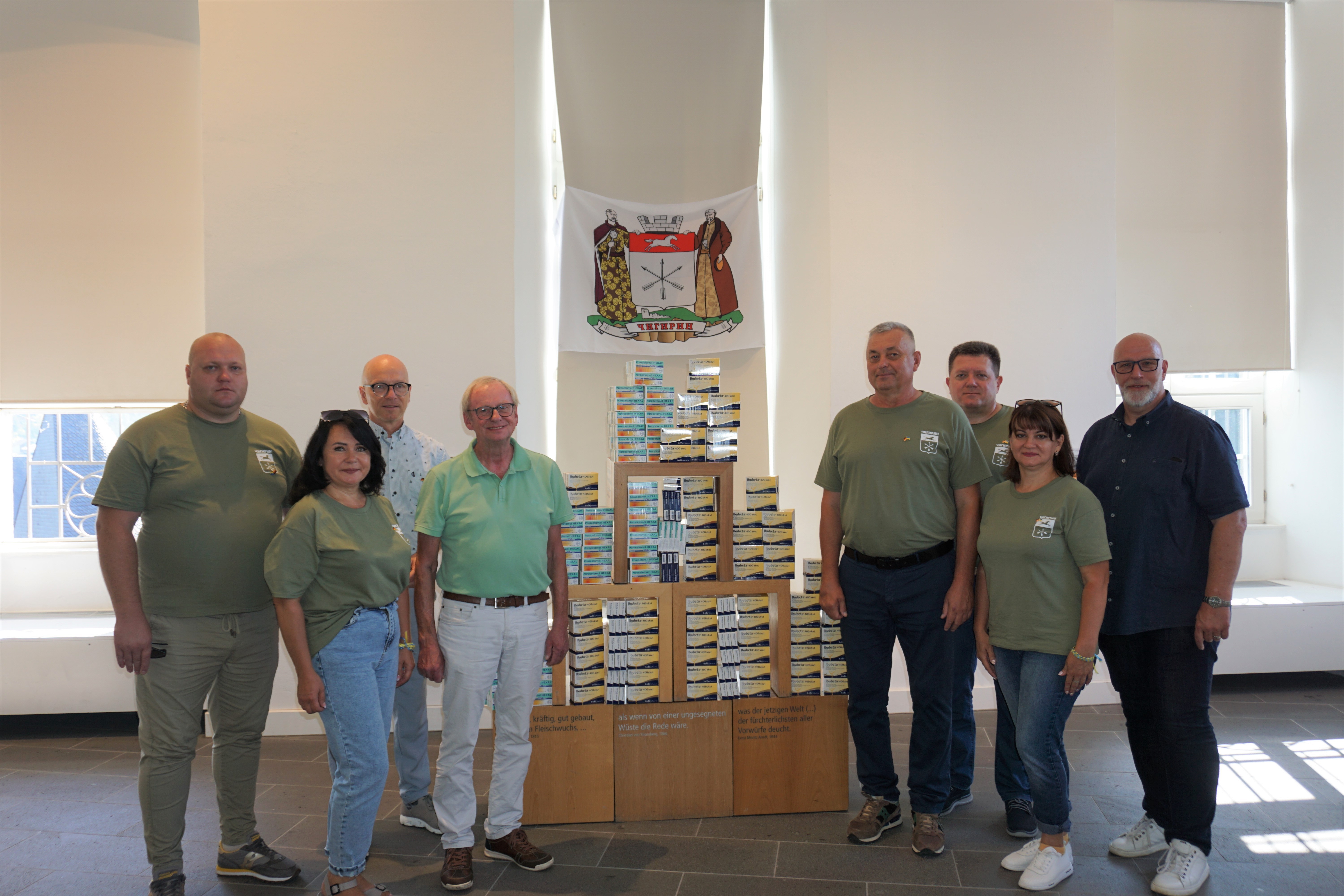 Eine Gruppe Menschen vor einem Tisch mit Medikamenten