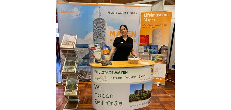 Eine Frau steht hinter einem Messestand