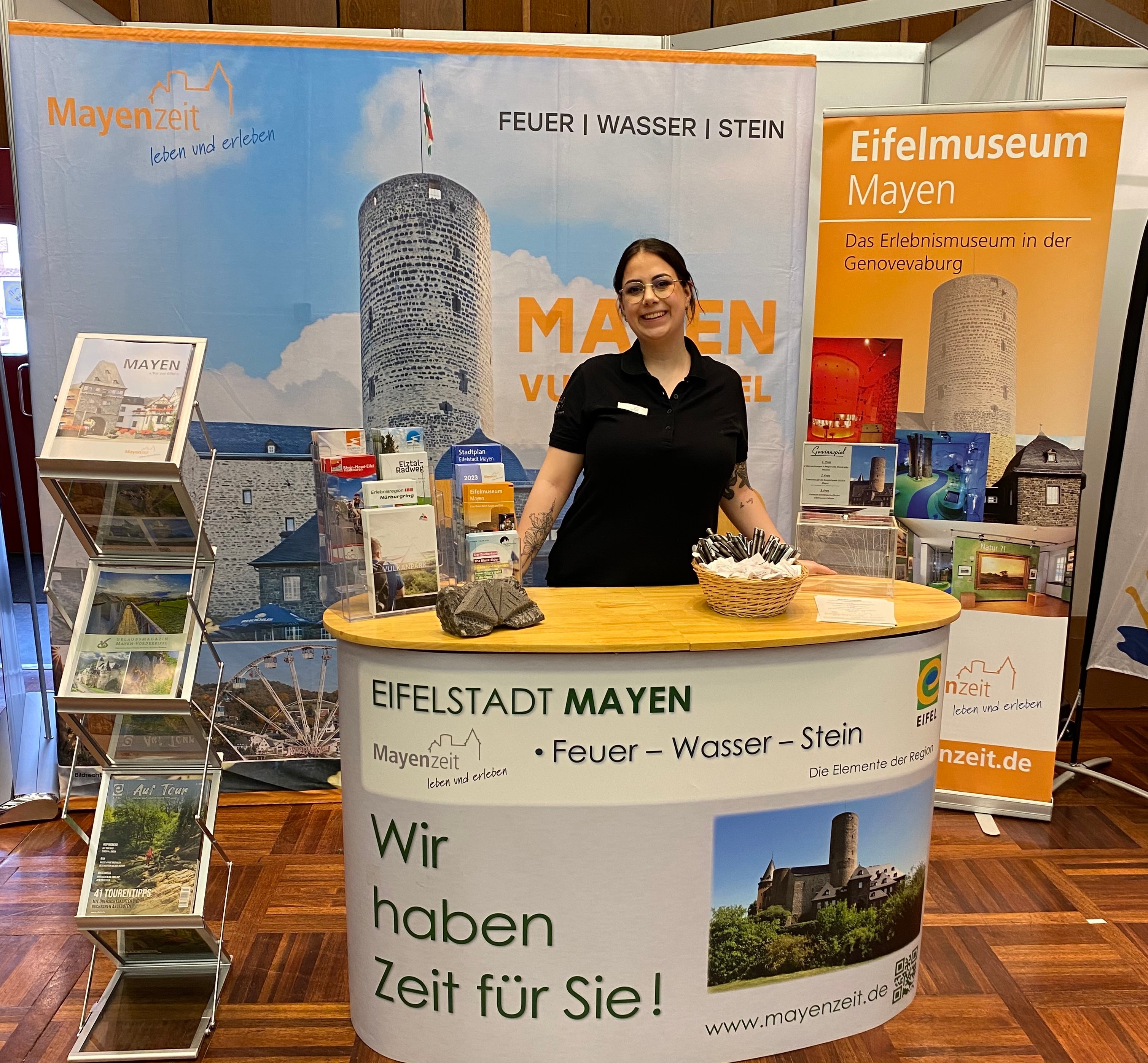Eine Frau steht hinter einem Messestand