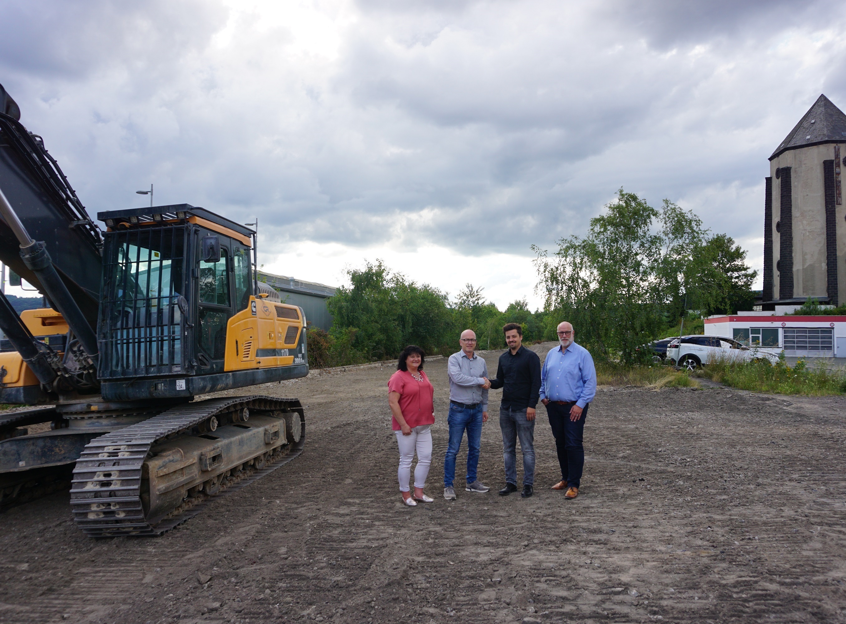 4 Personen stehen auf einem Schotterplatz