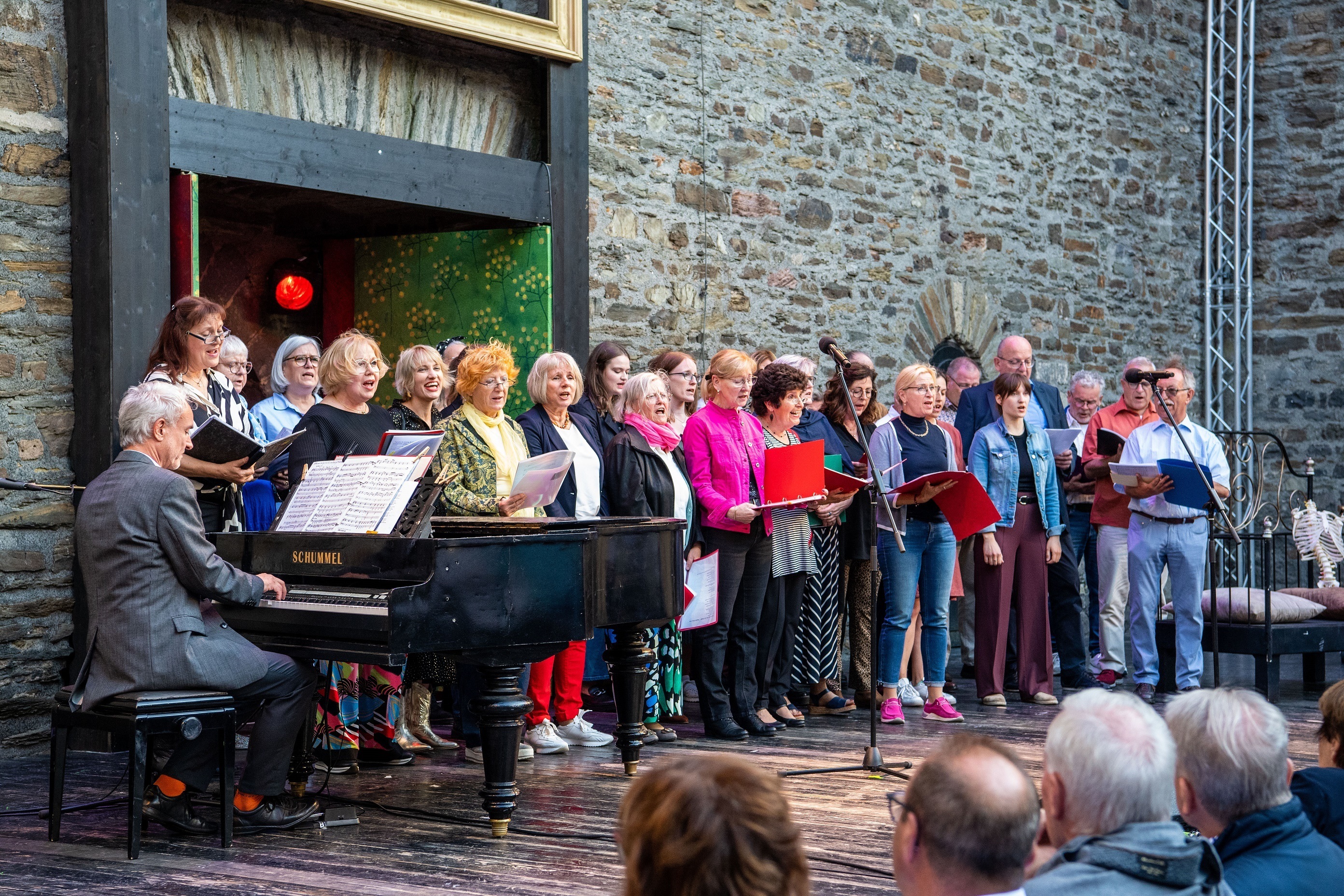 Mehrere Personen stehen auf einer Bühne und singen