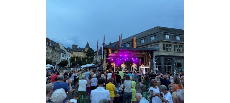 Die Band „One Night with ABBA“ lockte viele Zuhörerinnen und Zuhörer auf den Marktplatz Viele Menschen vor einer Bühne auf dem Marktplatz bei Dämmerung
