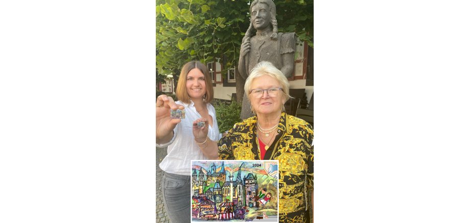 2 Frauen halten einen Pin in der Hand - dieser ist nochmal vergrößert abgebildet