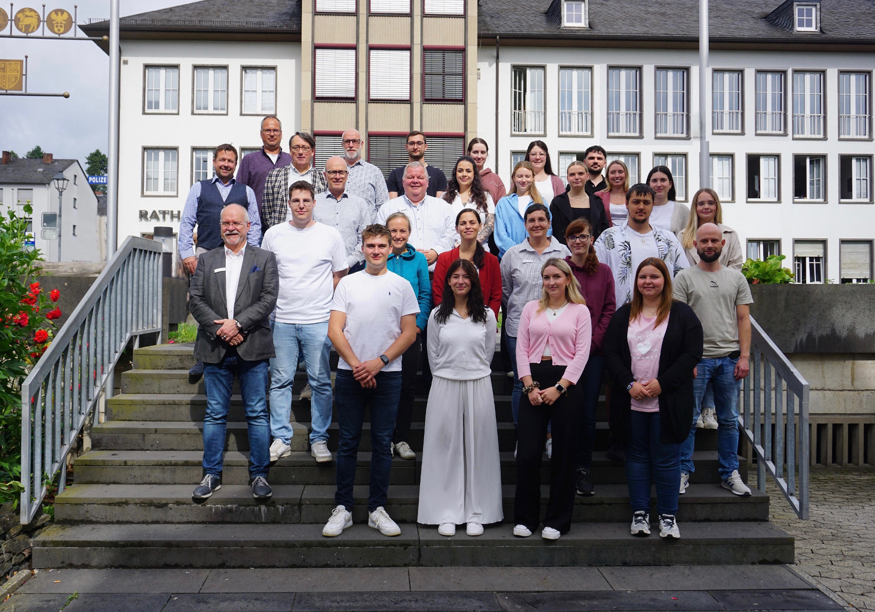 Mehrere Personen stehen auf der Treppe vor dem Mayener Rathaus