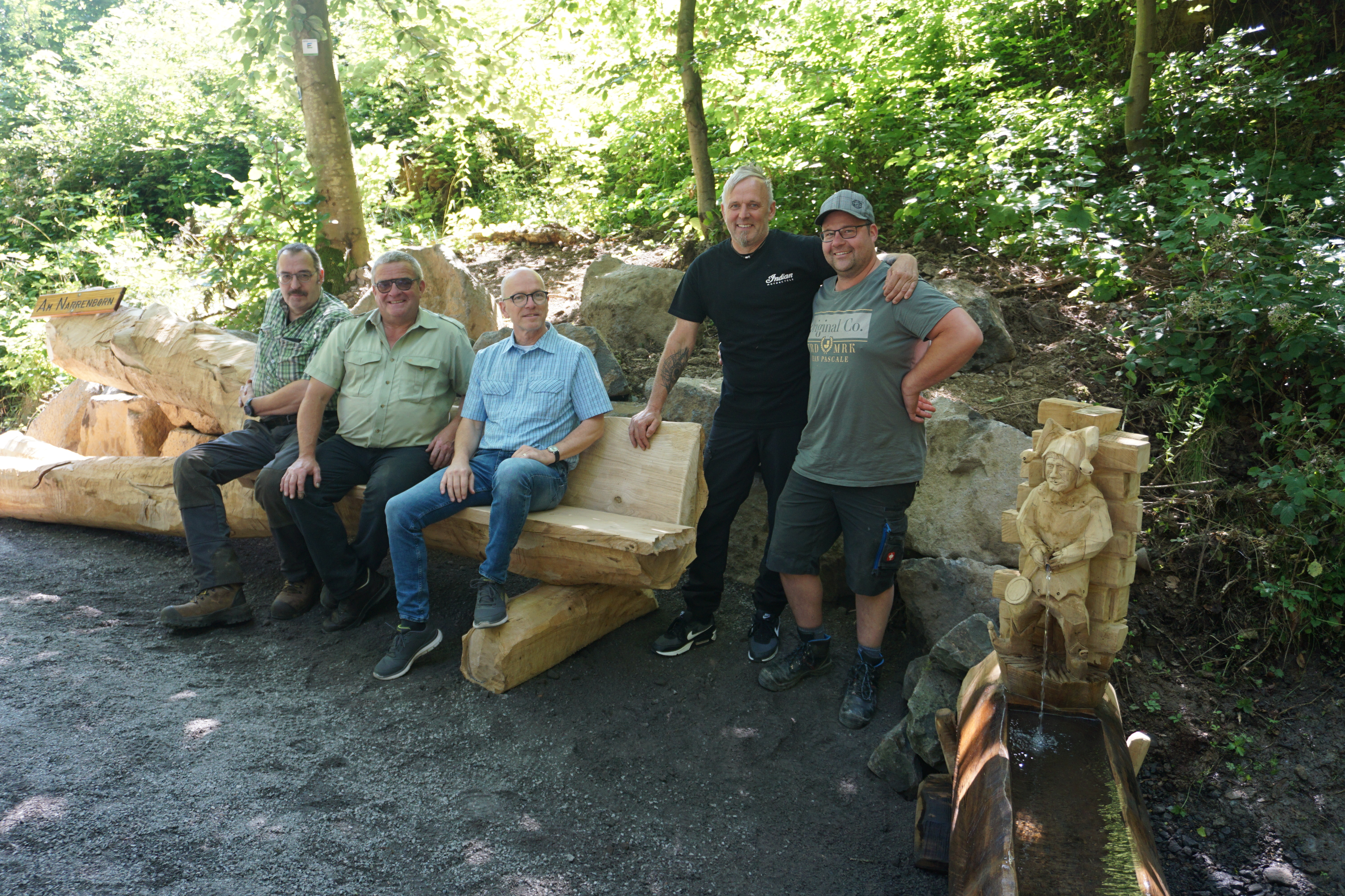 Fünf Personen auf einer Bank im Stadtwald
