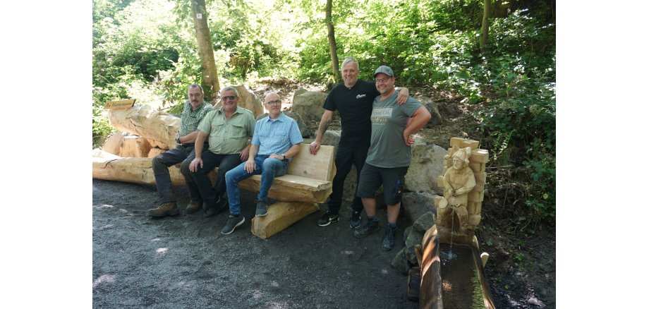 Fünf Personen auf einer Bank im Stadtwald