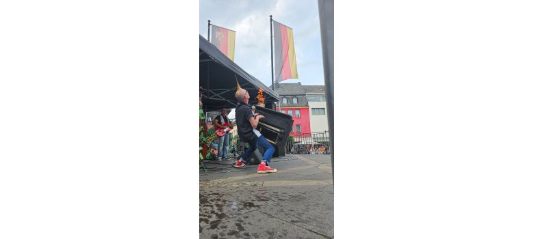 The Wild Bobbin‘ Baboons heizten den Marktplatz im wahrsten Sinne ein Mann mit einem kleinen Klavier in den Händen - im Hintergrund eine Flamme