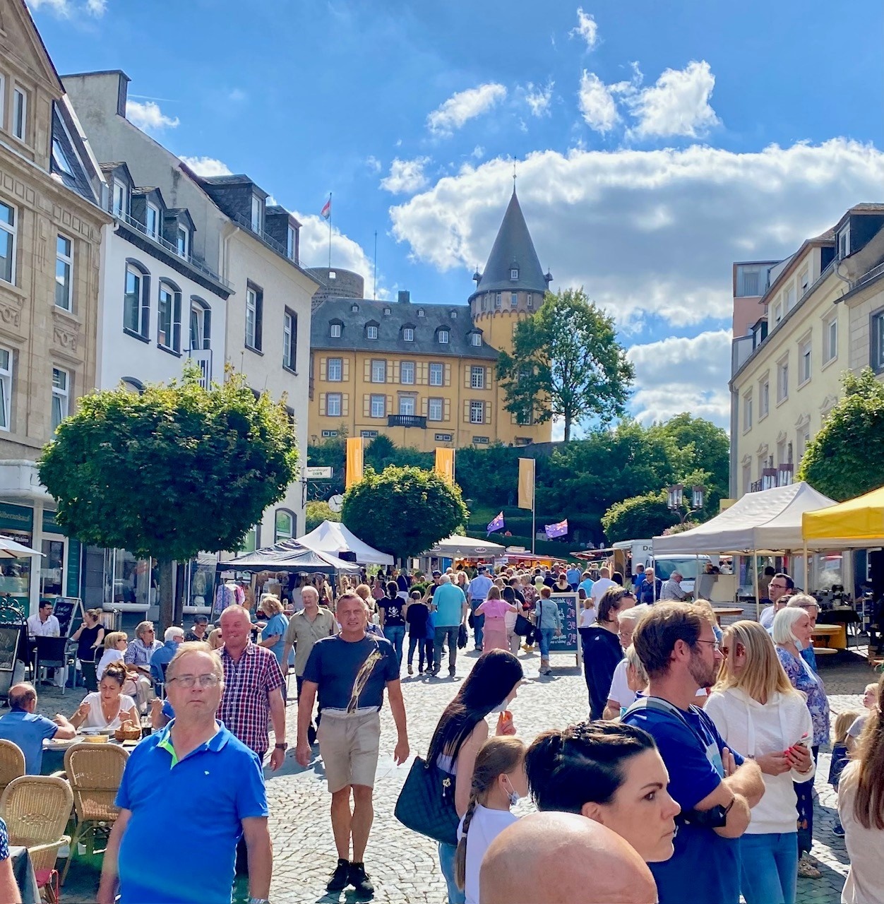 Ein voller Marktplatz - im Hintergrund die Burg