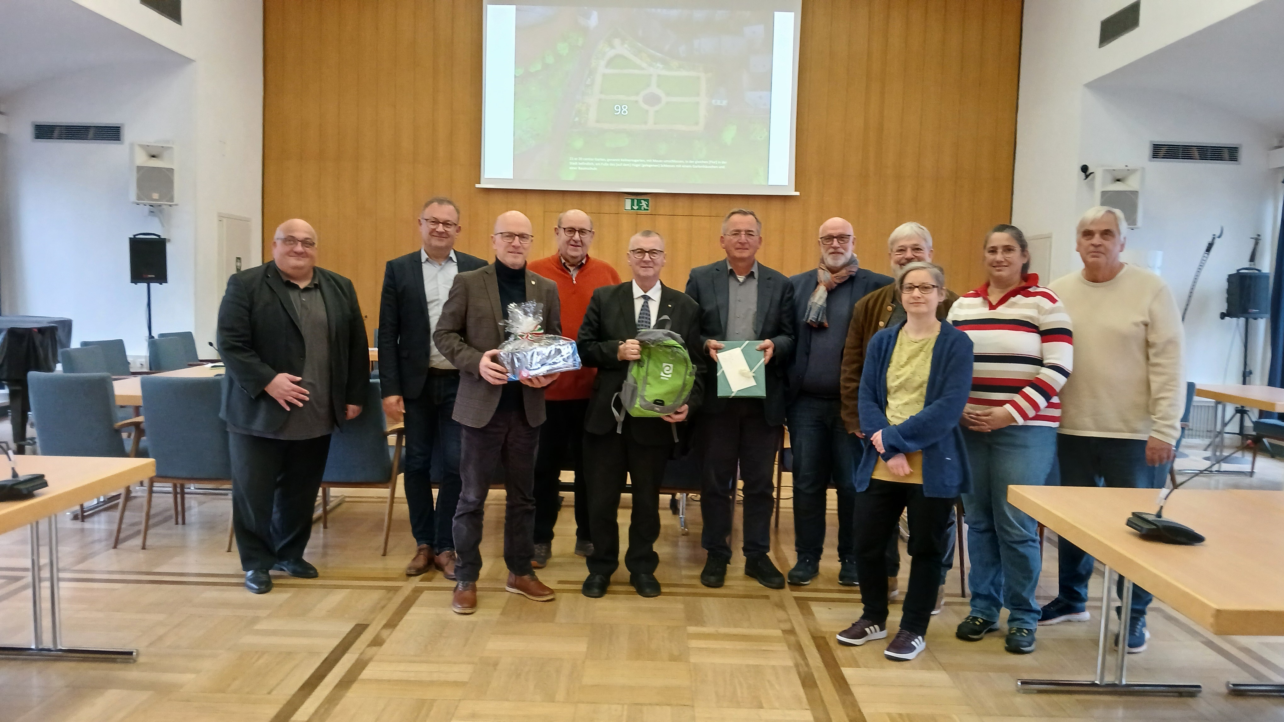 Mehrere Personen stehen zu einem Foto im Sitzungssaal zusammen. 