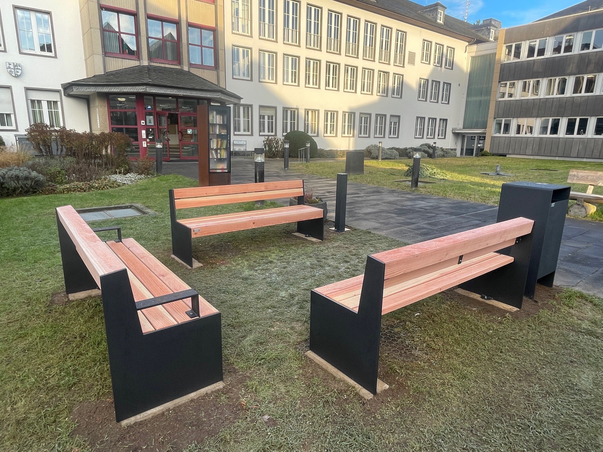 Vor dem Rathaus stehen drei neue Bänke und ein neuer Mülleimer