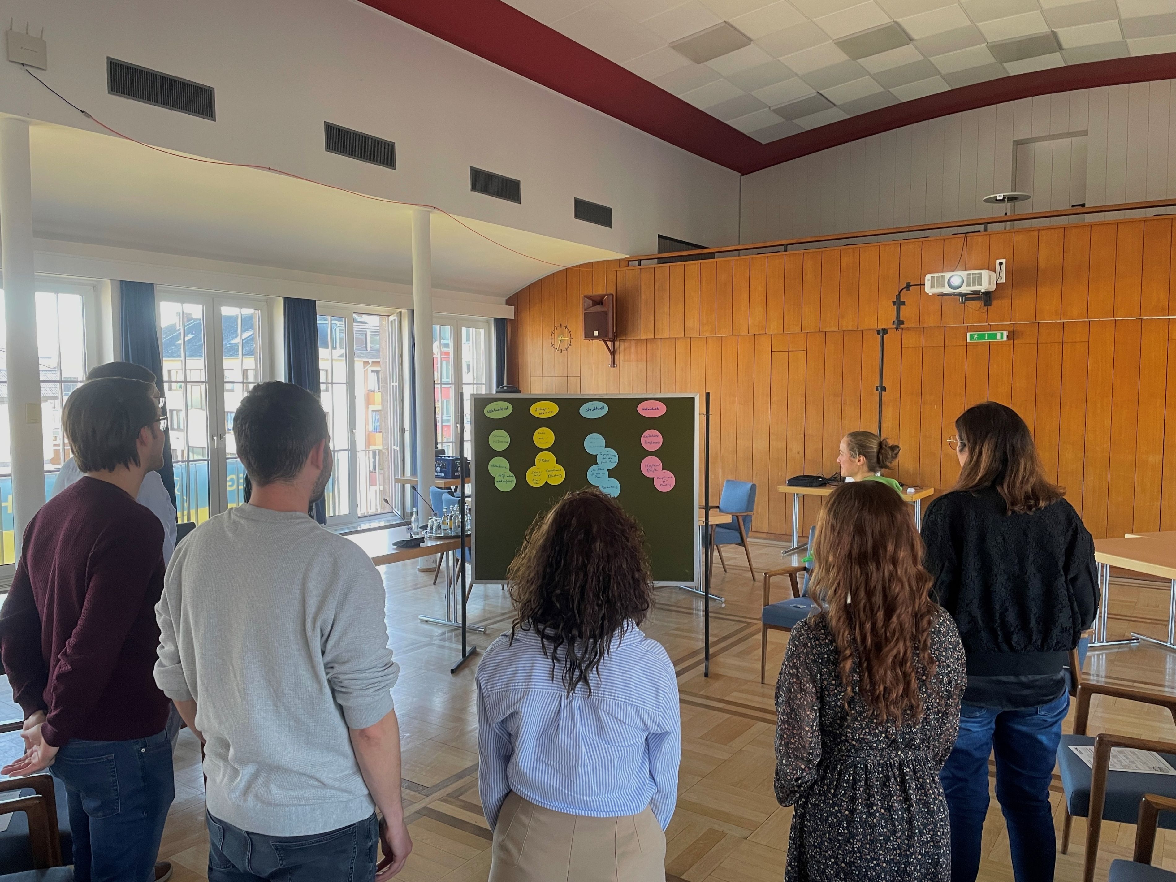 Die Beteiligten des Workshops beim gemeinsamen Austausch Eine Gruppe von Personen im Kreis beim Workshop