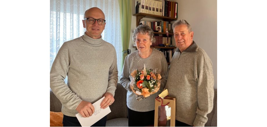 Oberbürgermeister Dirk Meid (links) mit Hildegard und Siegfried Schulz 3 Personen - in der Mitte eine Frau mit einem Blumenstrauß