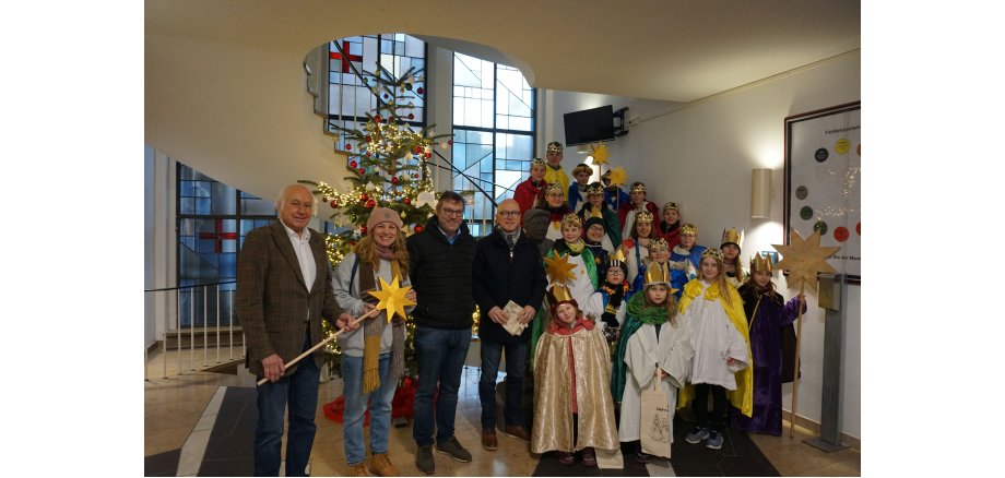 Vier Personen mit vielen Kindern im Rathaus