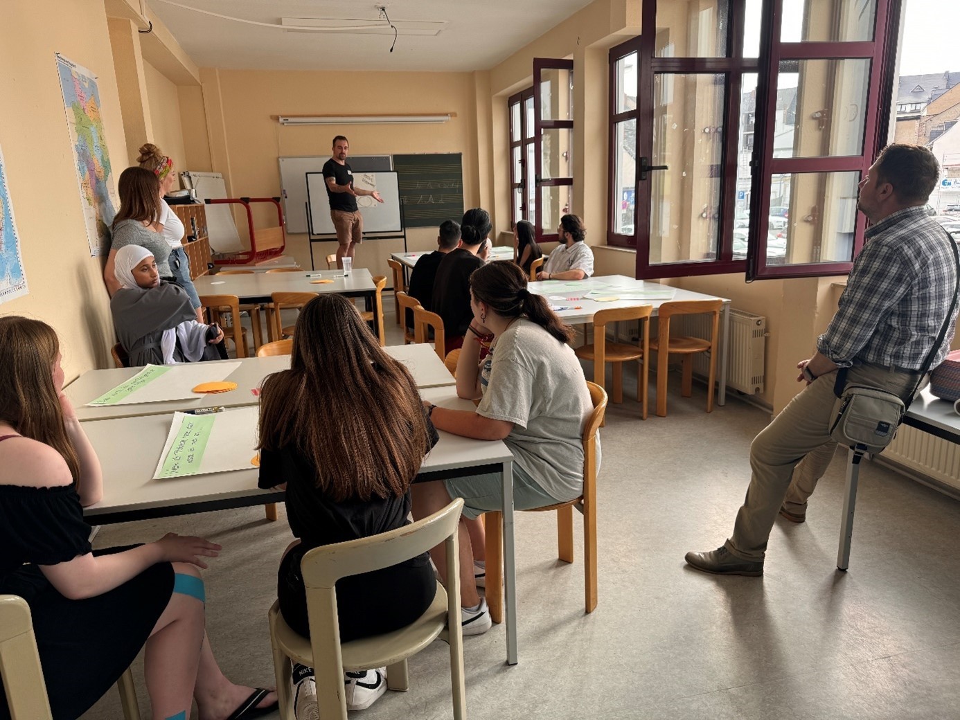 Jugendliche in einem Raum an Tischen arbeitend