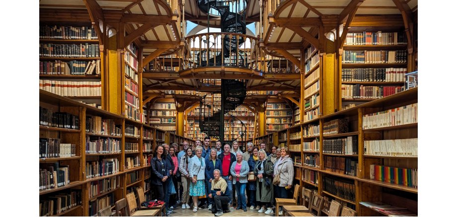 Eine Gruppe steht im Gang einer Bibliothek