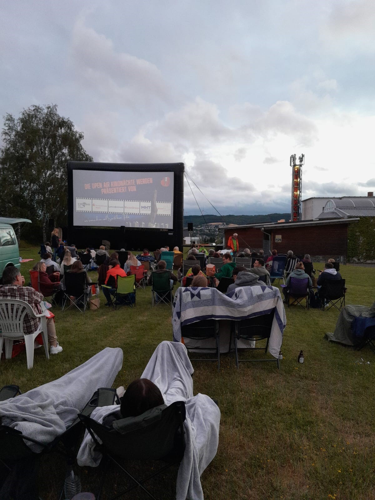 Viele Personen mit Campingstühlen im Open-Air KIno