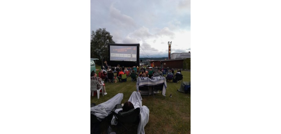 Viele Besucherinnen und Besucher beim Open-Air Kino im Mayener Grubenfeld Viele Personen mit Campingstühlen im Open-Air KIno