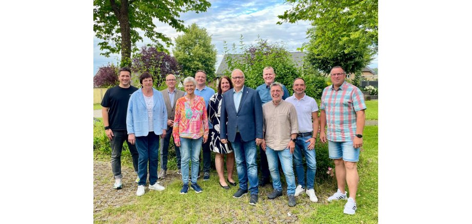 Gruppe von Personen steht auf einem Parkplatz für ein Foto zusammen