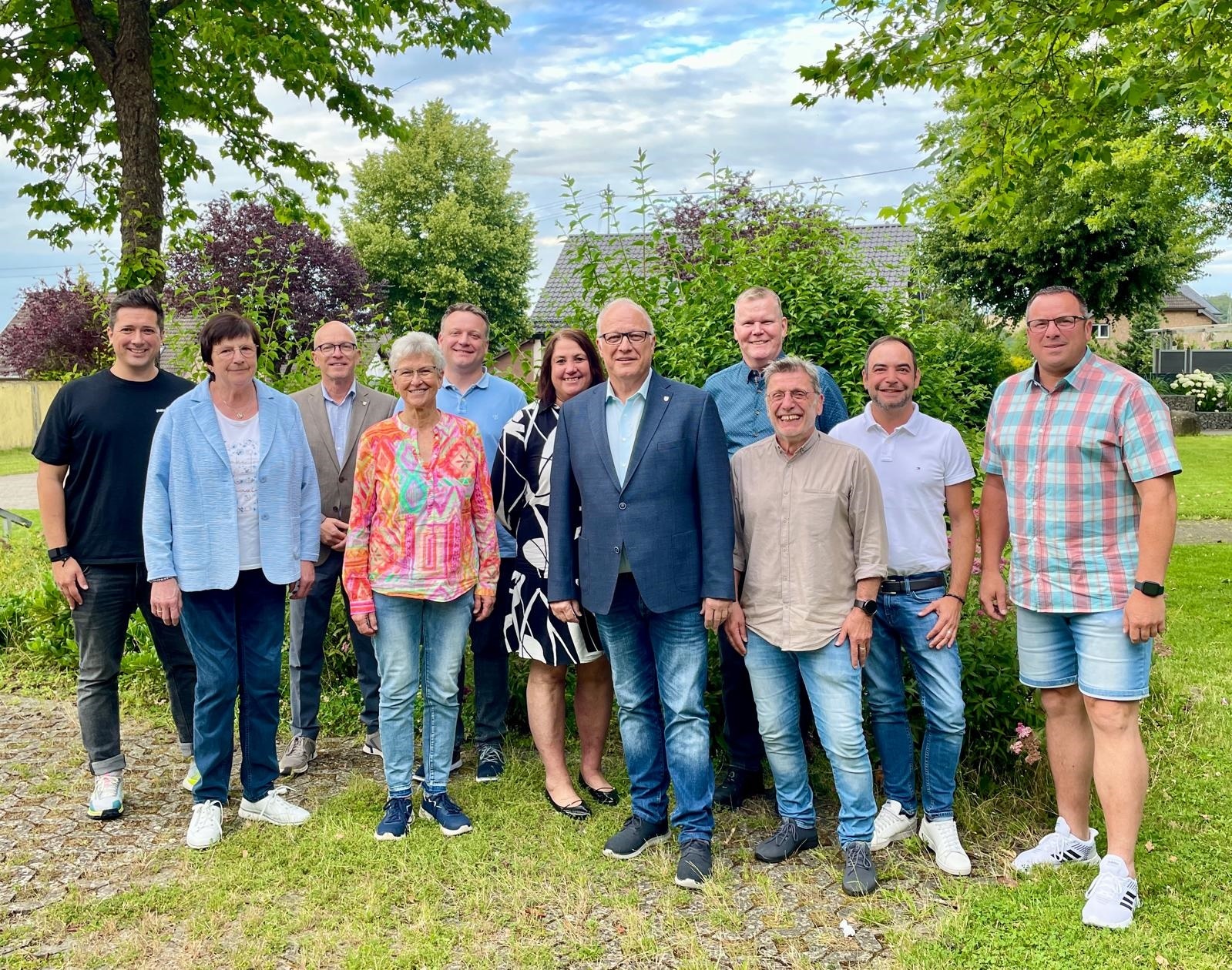 Gruppe von Personen steht auf einem Parkplatz für ein Foto zusammen