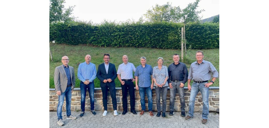 Mehrere Personen stehe vor einer Grünanlage