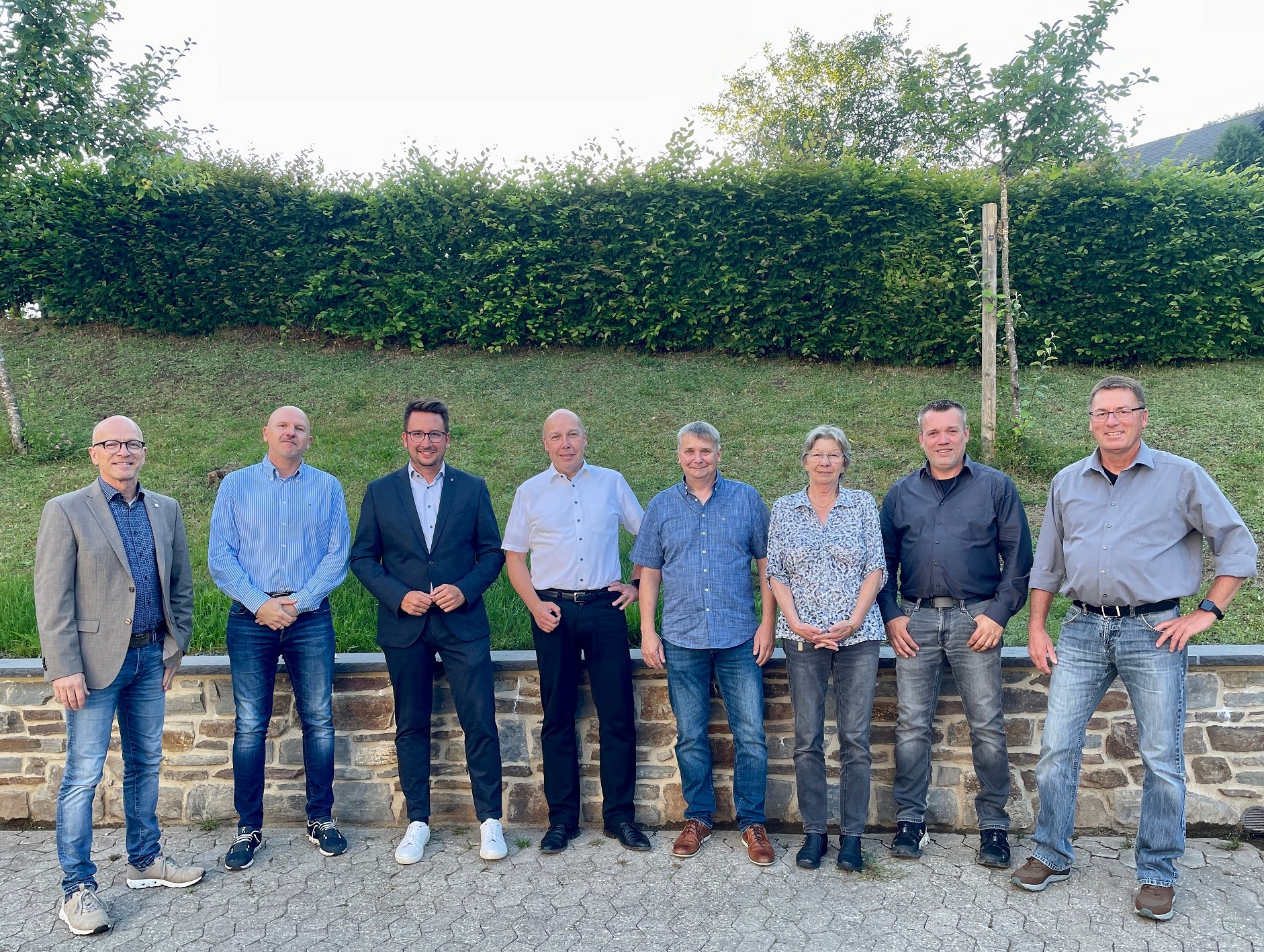 Mehrere Personen stehe vor einer Grünanlage