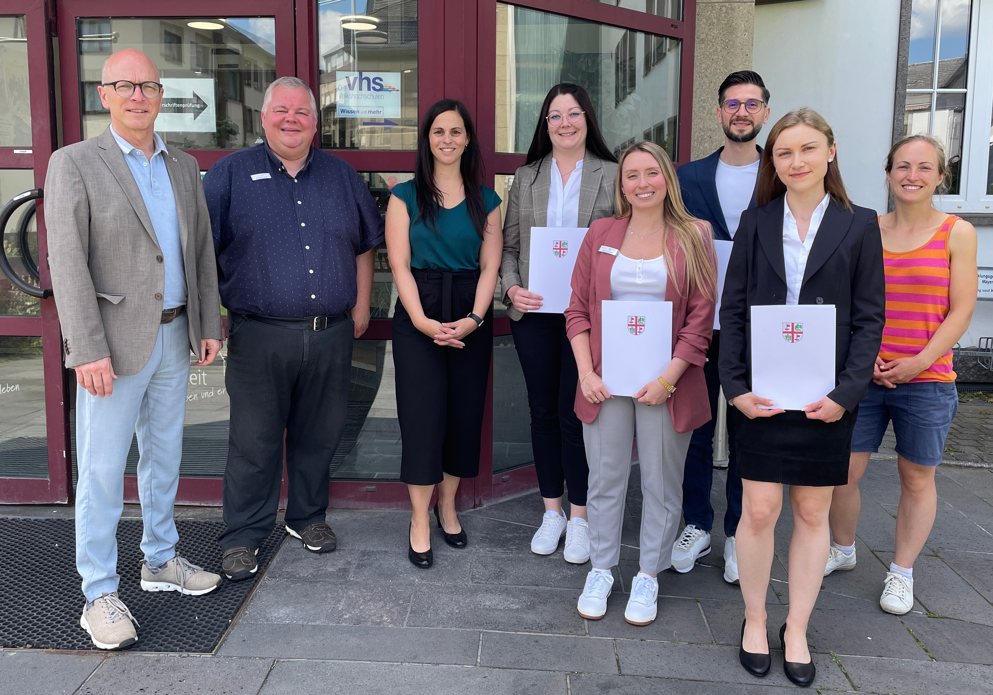 v.l.n.r.: Oberbürgermeister Dirk Meid, Personalratsvorsitzender Wolfgang Goeken, Büroleiterin Jasmin Alter, Sabrina Retterath, Isabell Verhagen, Mohamad Al Emam. Emelie Hill und Gleichstellungsbeauftragte Dr. Ina Rüber-Teke 8 Personen stehen vor dem Eingang des Rathauses - einige halten eine Urkunde in den Händen