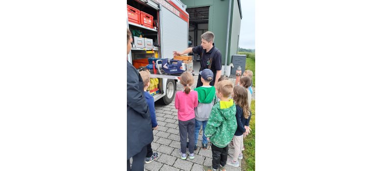 Jugendwart Uwe Gilles mit Kindergartenkinder neben dem Feuerwehrauto
