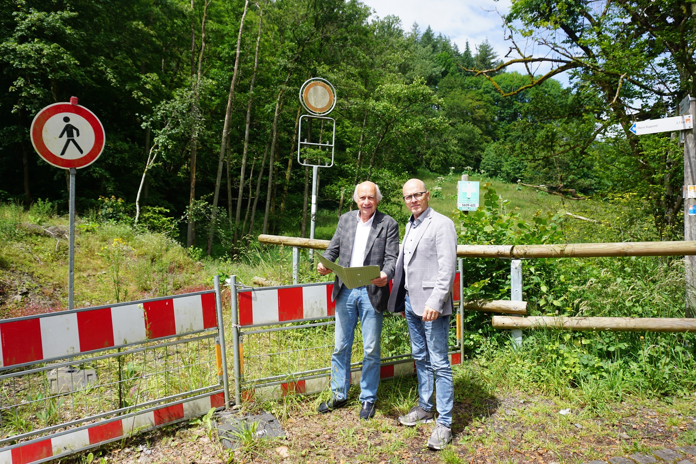2 Männer stehe mit einem Plan an einer Baustelle