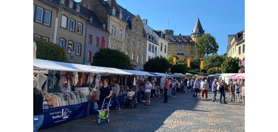 Der Stoff- und Tuchmarkt lädt am 21. Juni in die Innenstadt von Mayen ein Mehrere Menschen an verschiedenen Marktständen