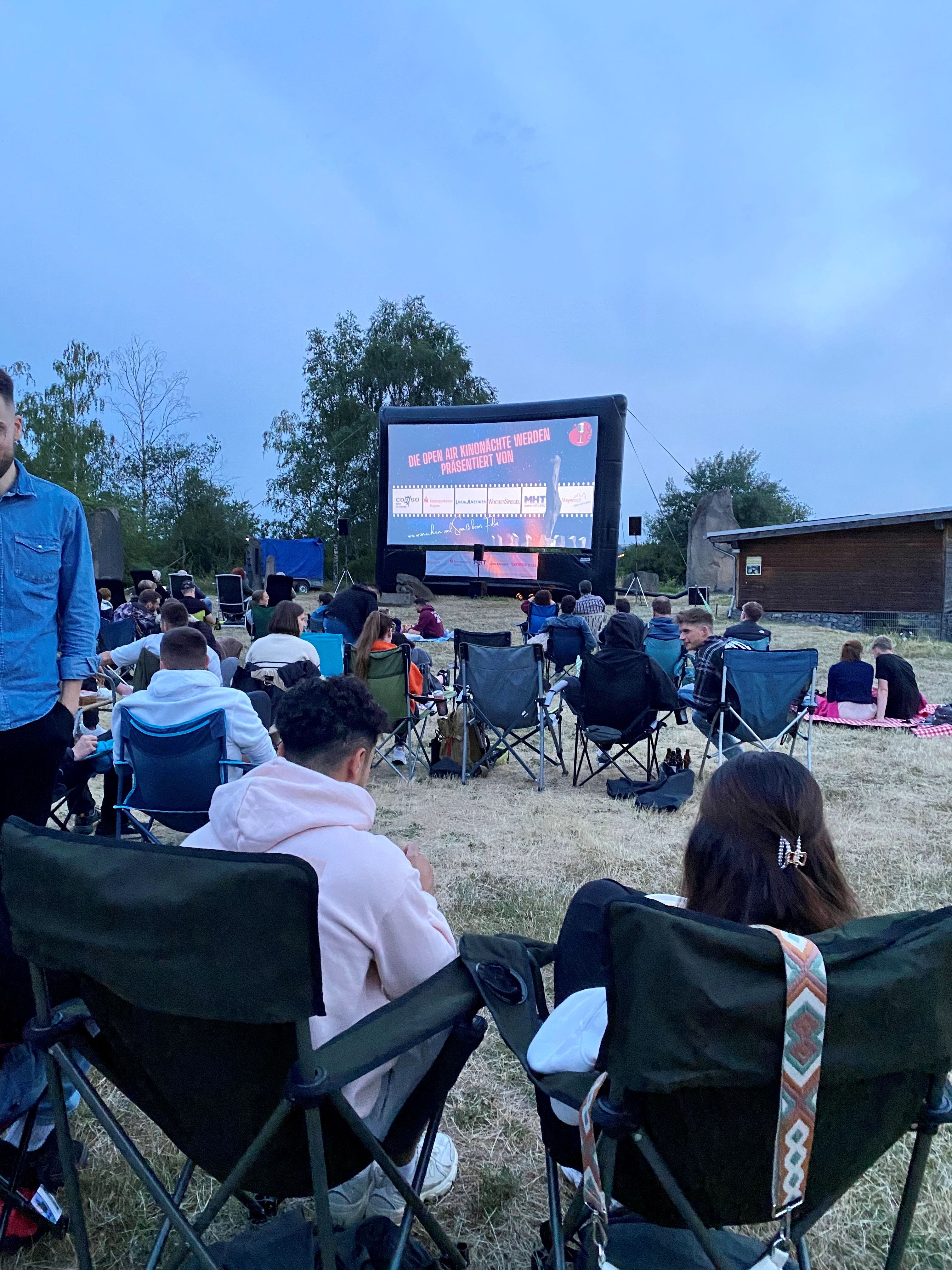 Viele Besuchende auf der Wiese beim Open-Air Kino im Mayener Grubenfeld