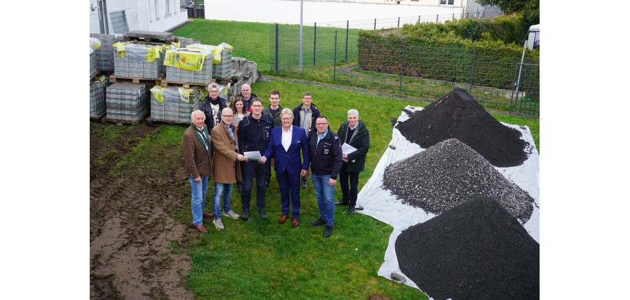 Vertreter der Stadt, der Stadtwerke, dem Architektenbüro und der Feuerwehr bei der Übergabe des Pachtvertrages Personengruppe steht für ein Bild zusammen - 2 Personen übergeben einen Vertrag