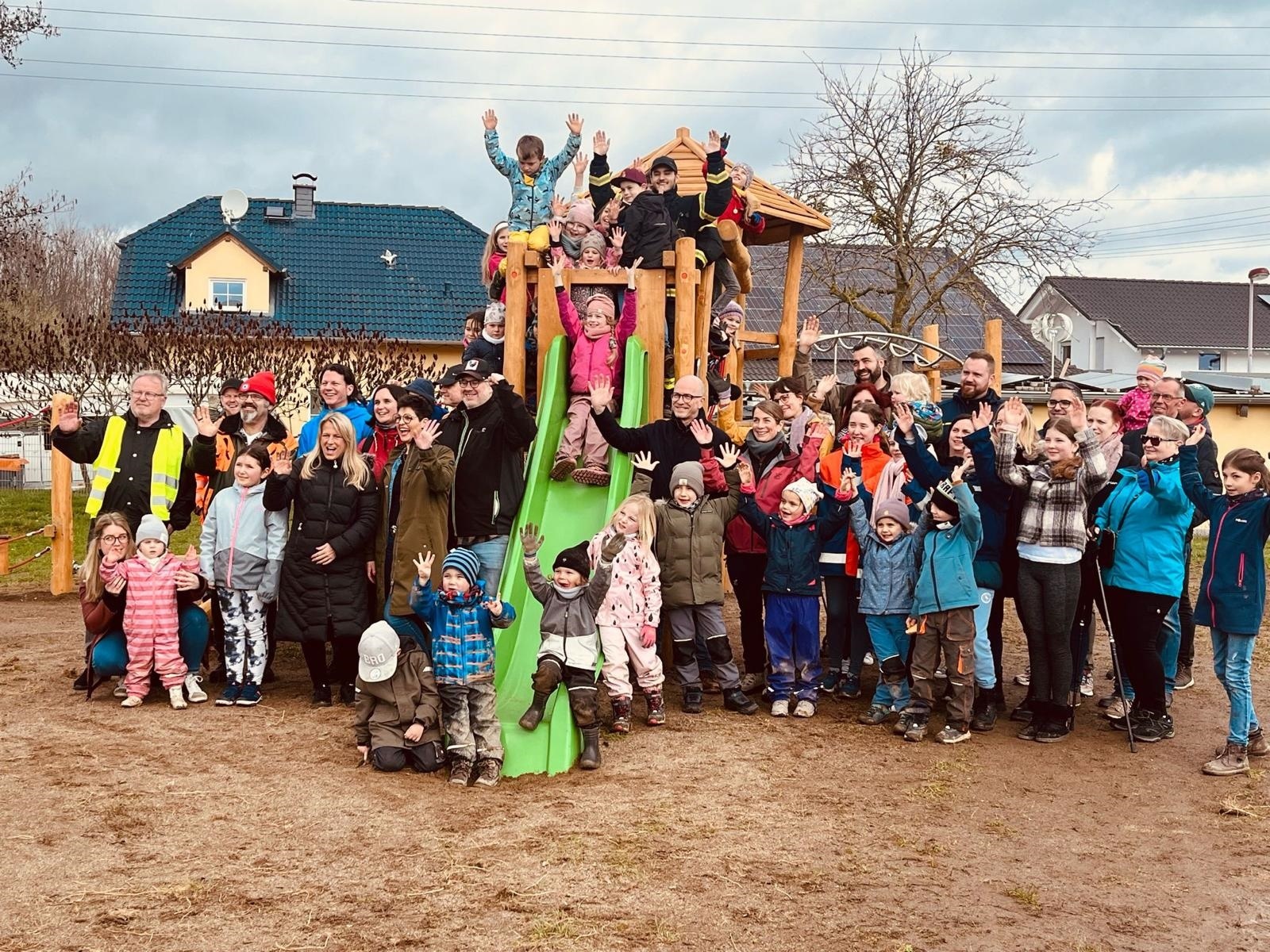 Viele Kinder stehen an einem neuen Klettergerüst für ein Bild zusammen