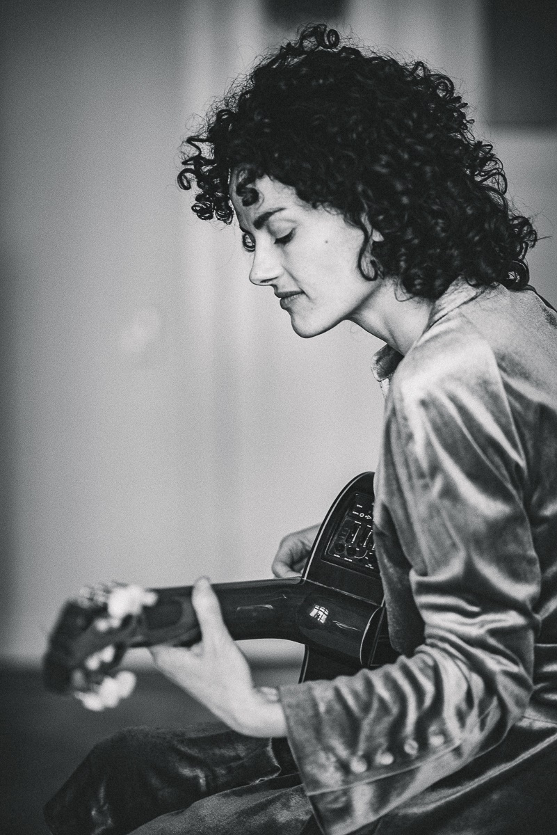 Bild von einer Frau mit einer Gitarre in schwarz-weiß