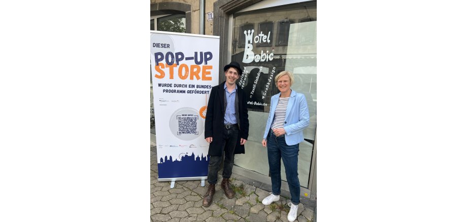 2 Personen vor dem neu eröffneten Geschäft