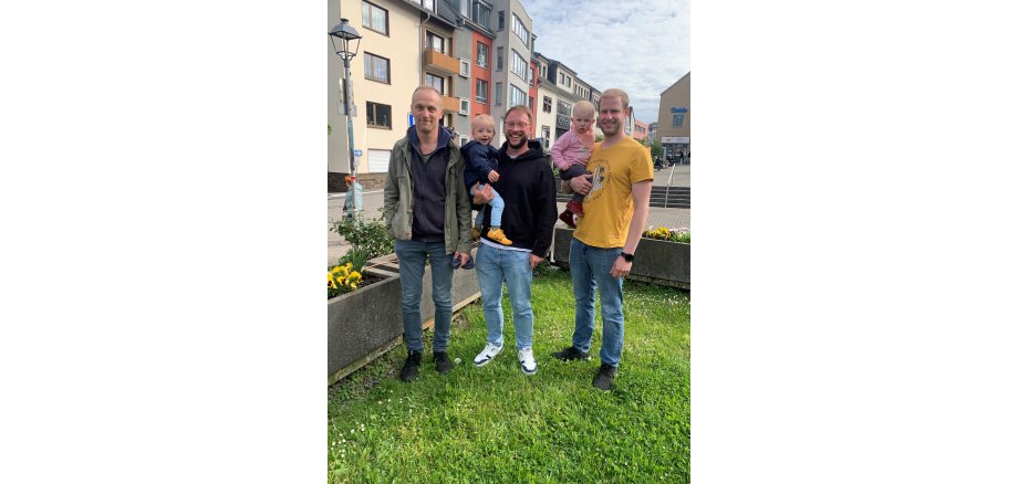 Drei Männer und zwei Kinder vor dem Rathaus