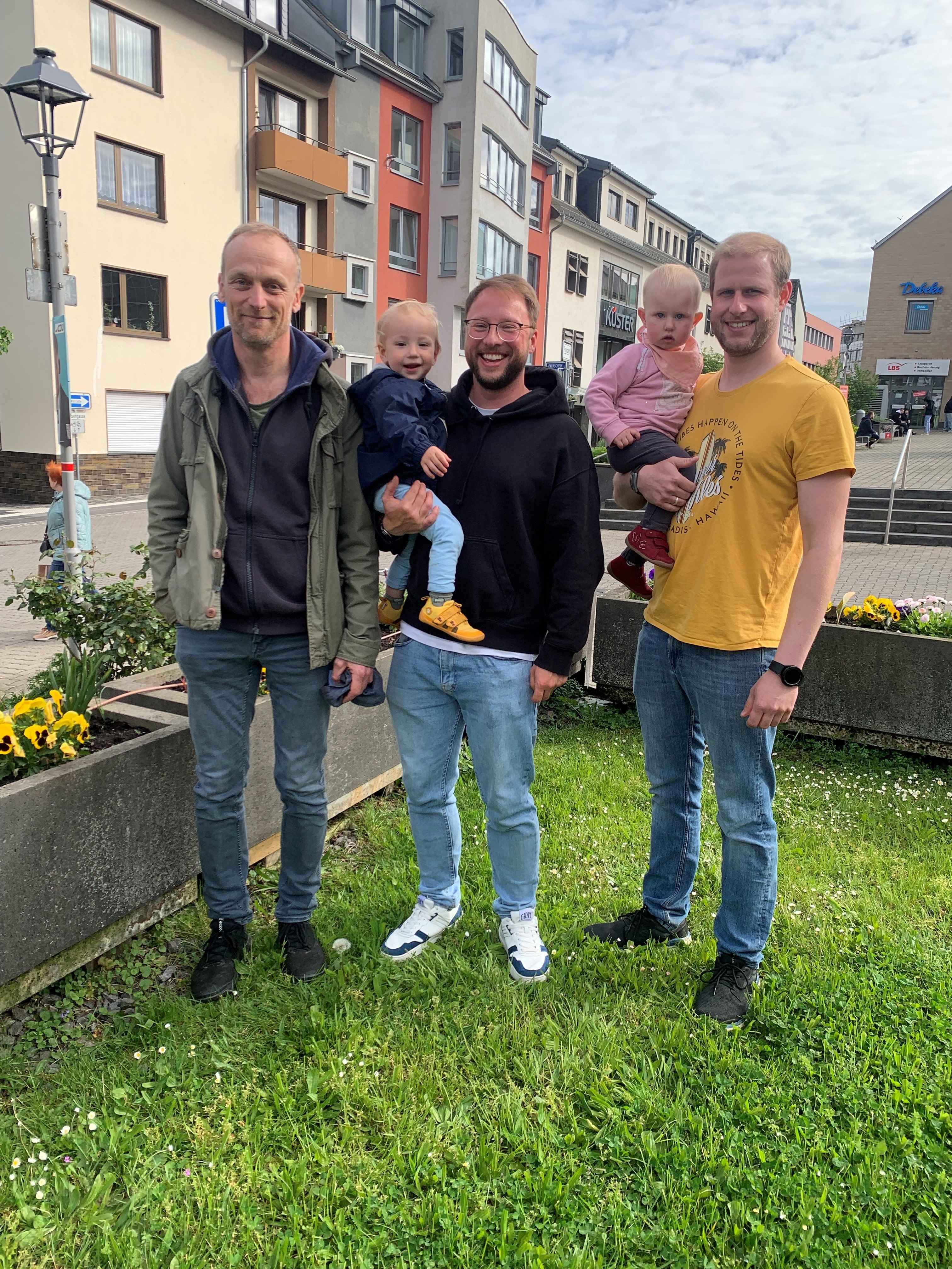 Drei Männer und zwei Kinder vor dem Rathaus