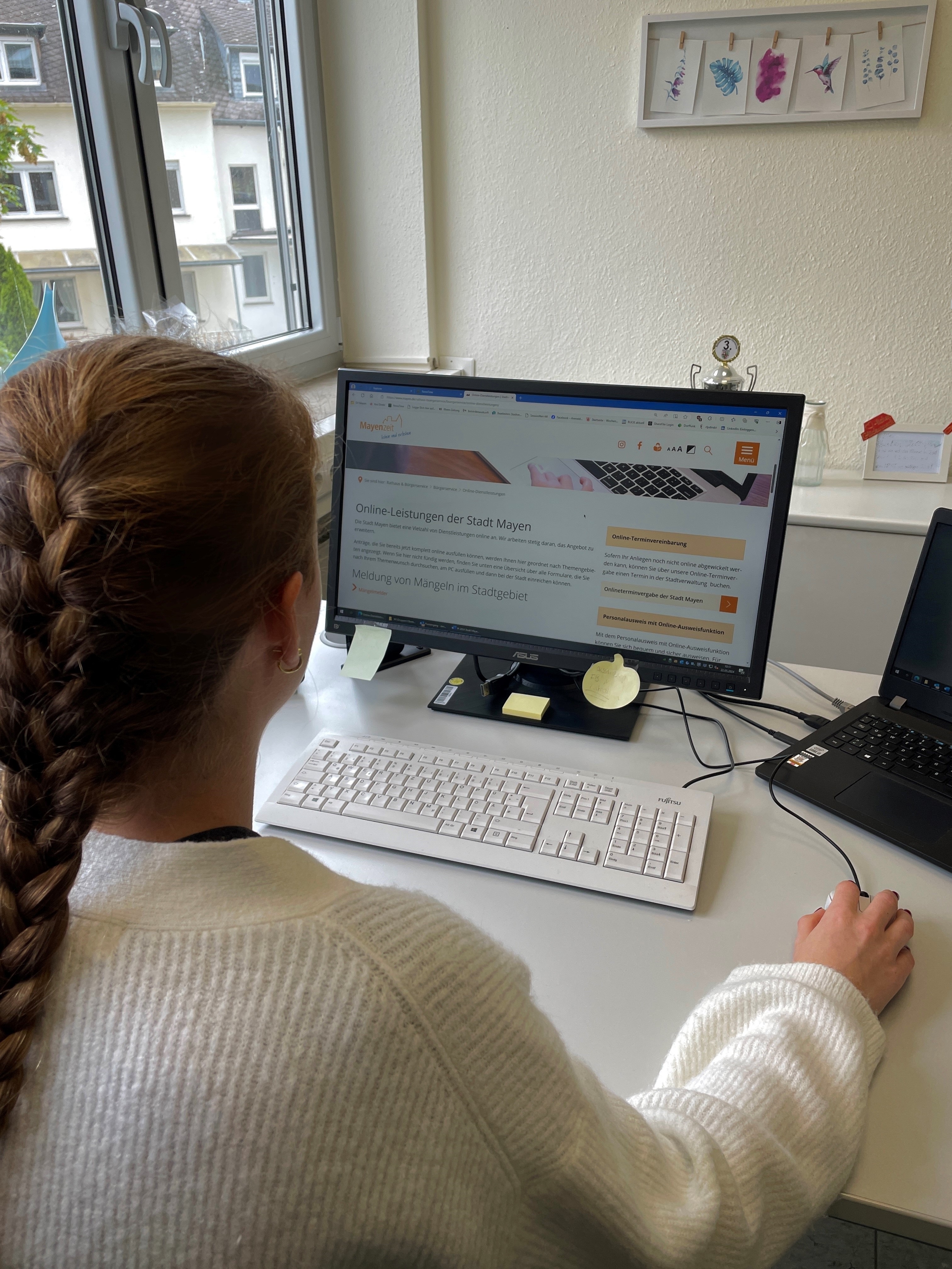 Frau sitzt am Computer und informiert sich über die Onlinedienstleistungen der Stadt Mayen