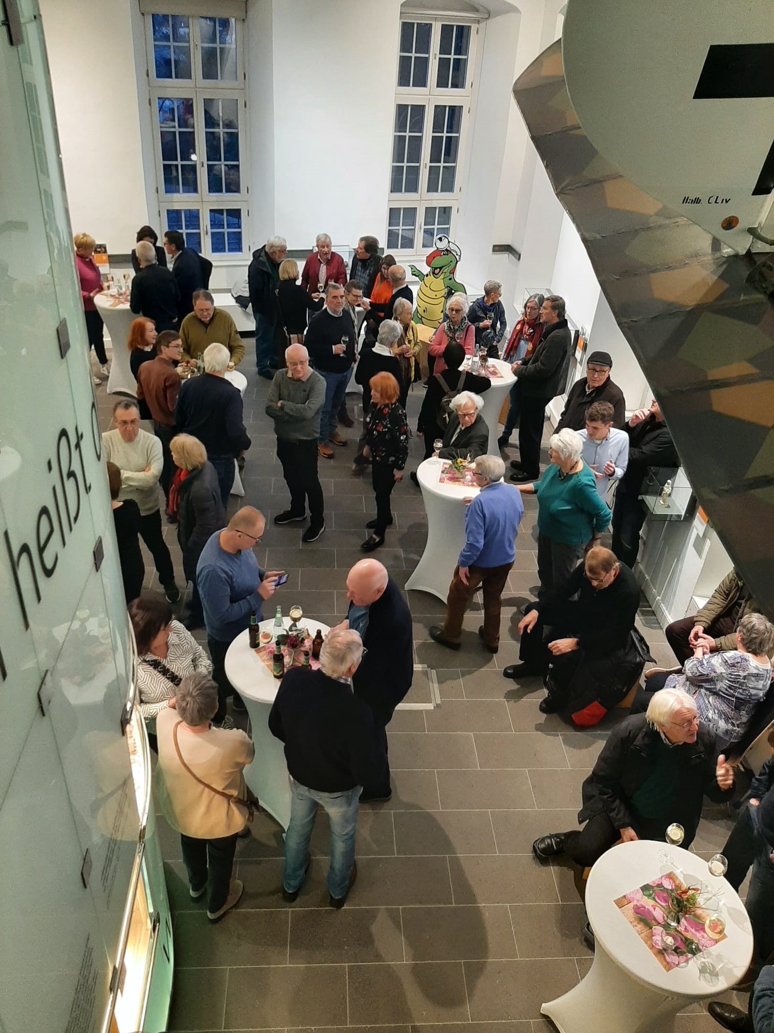 Mehrere Menschen stehen in einem Raum zusammen und unterhalten sich