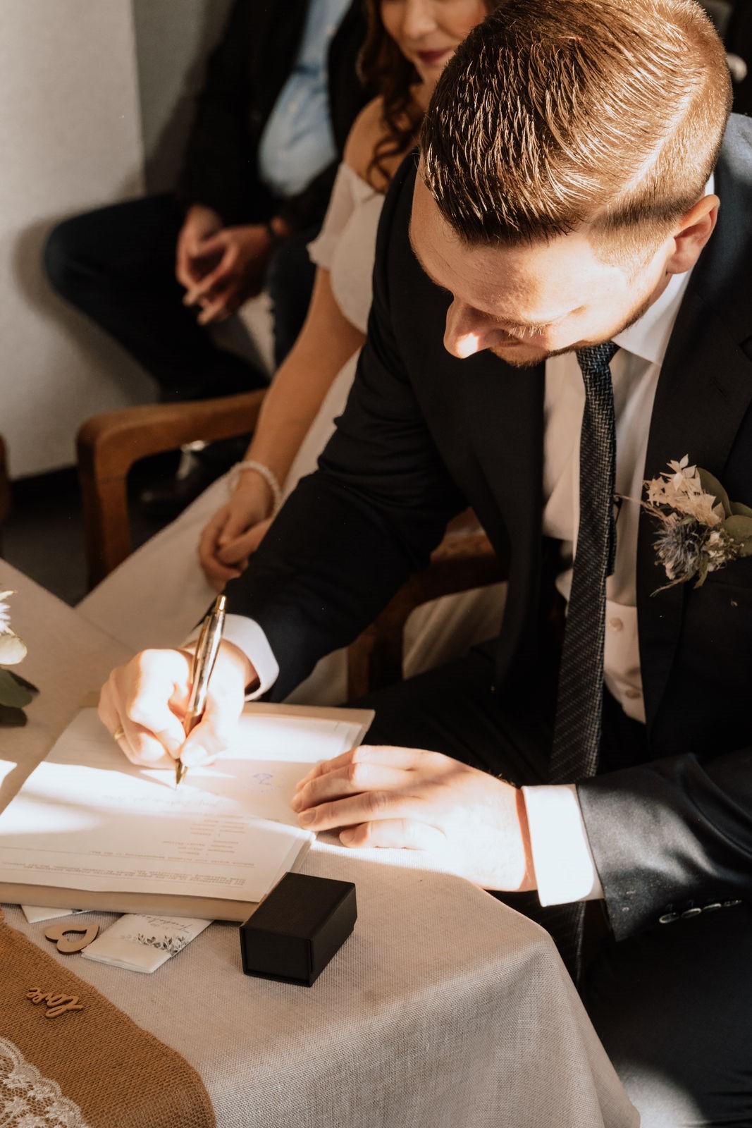 Ein Mann in Anzug unterschreibt Unterlagen