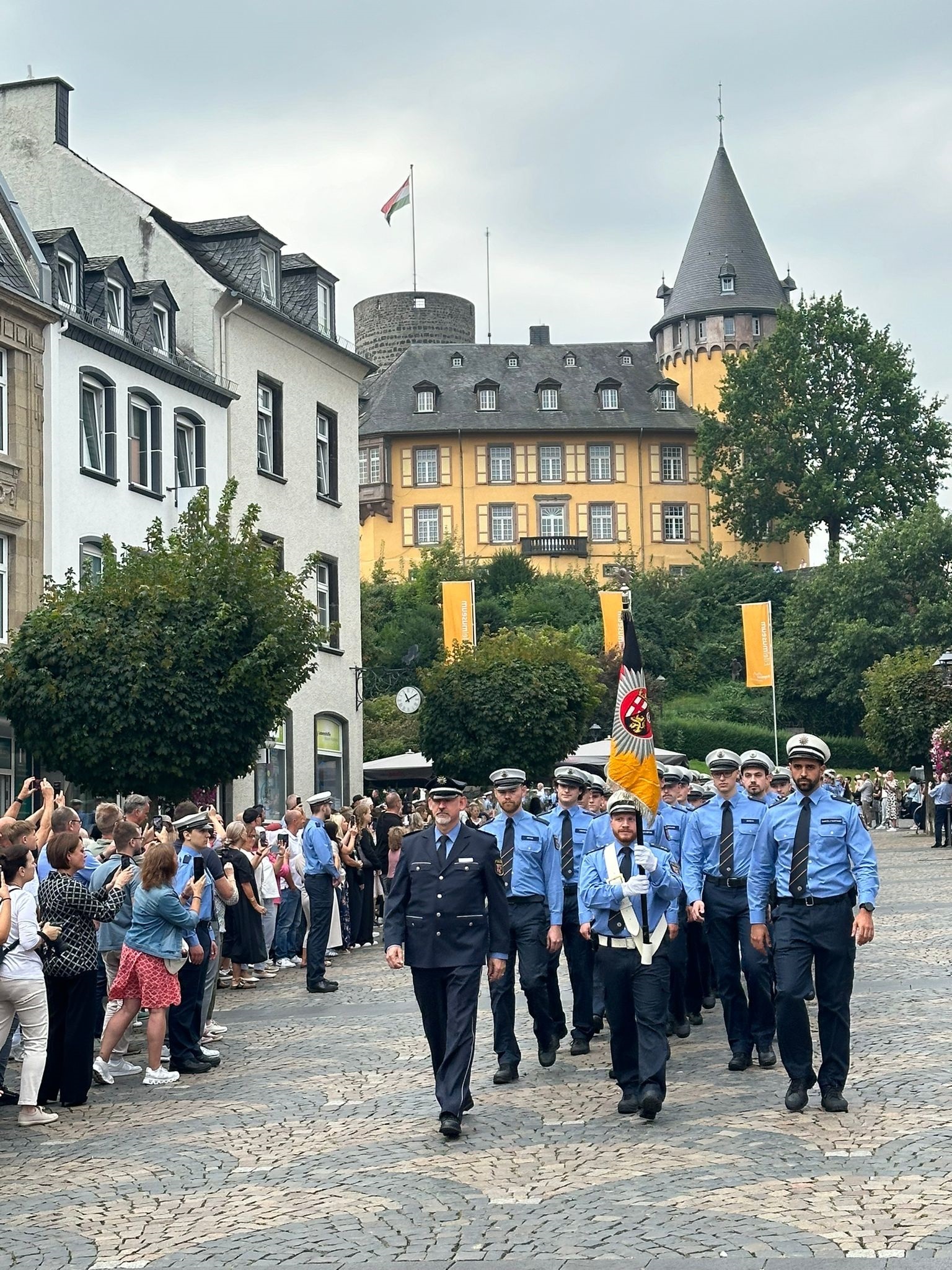 Mehrere Personen marschieren in Uniform auf den Marktplatz
