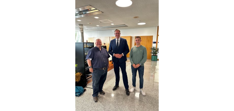 Drei Personen auf einem Messegelände