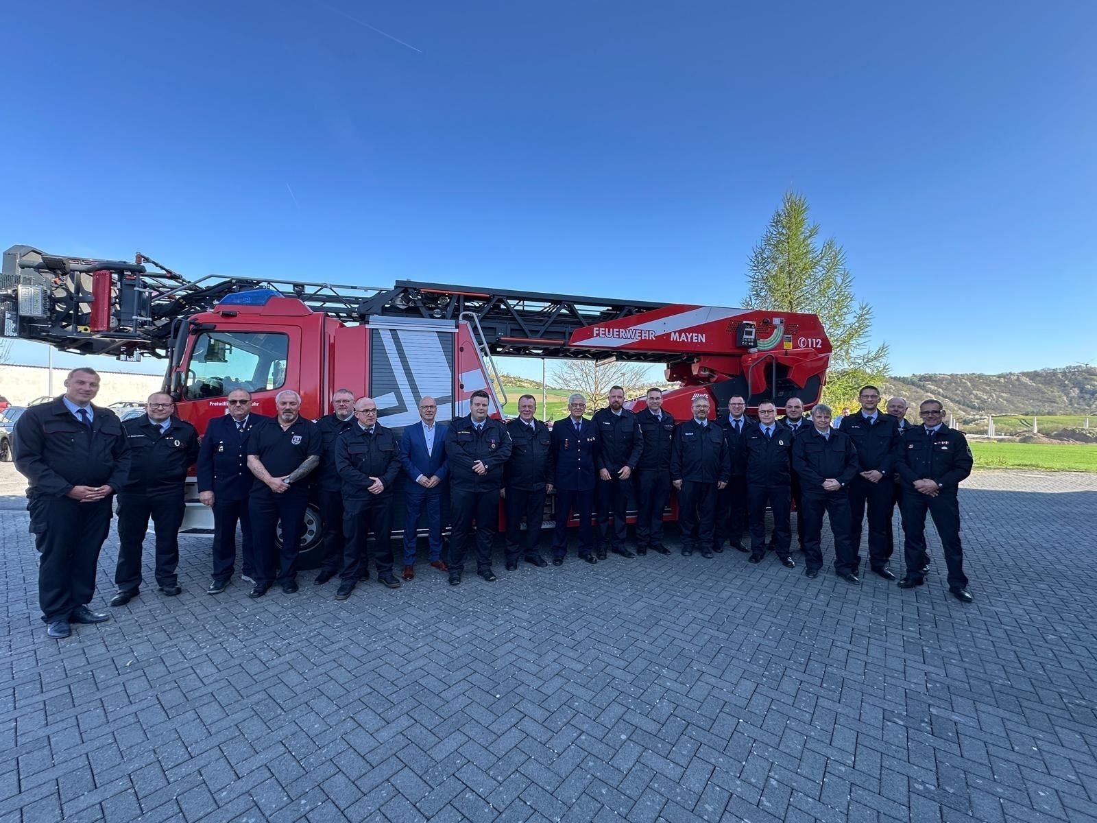 Männer in Uniform stehen vor einem Feuerwehrauto