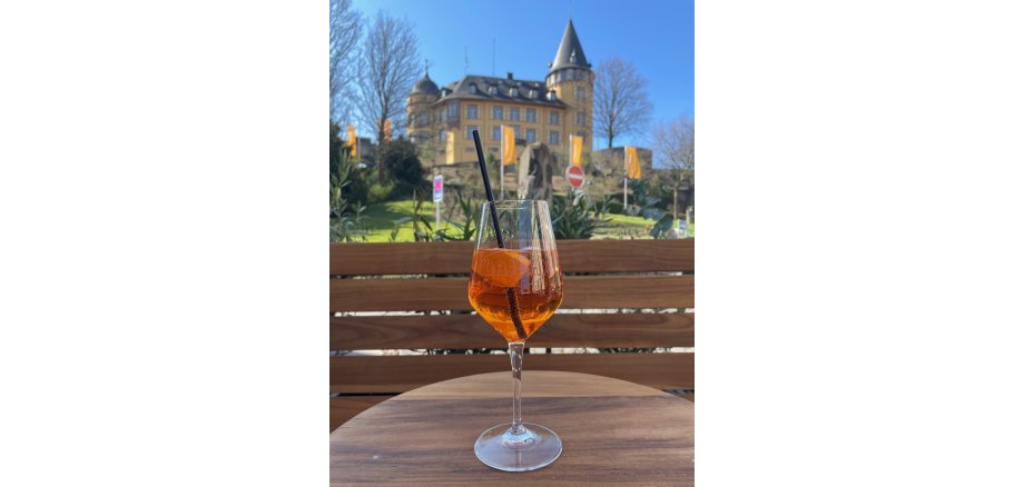 Ein Getränk auf einem Tisch vor der Burgkulisse