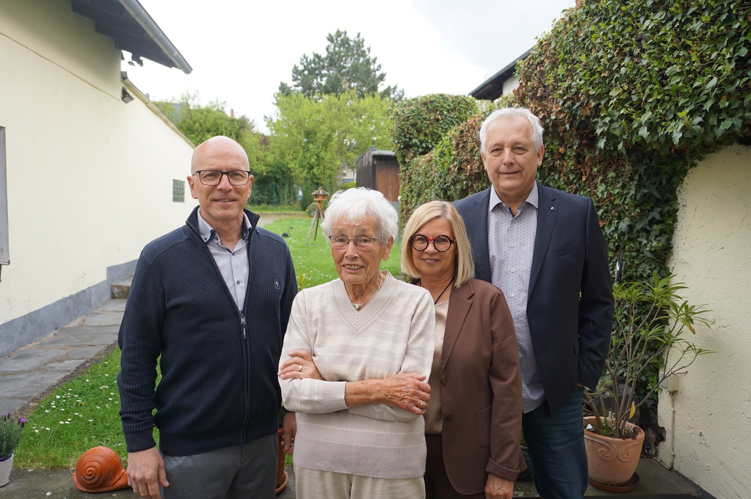2 Frauen und 2 Männern stehen im Garten für ein Foto