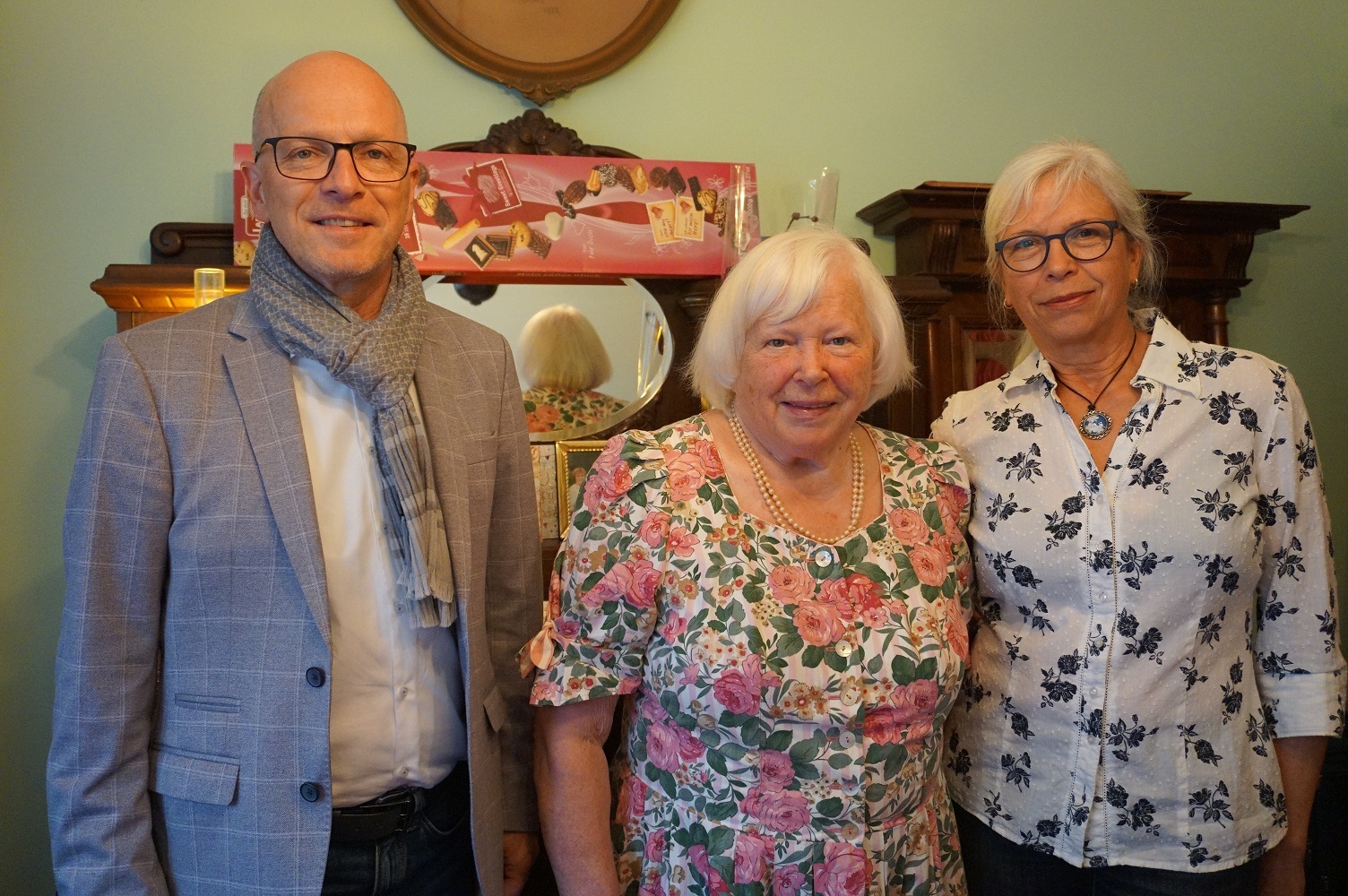 Zwei Frauen und ein Mann stehen für ein Foto zusammen