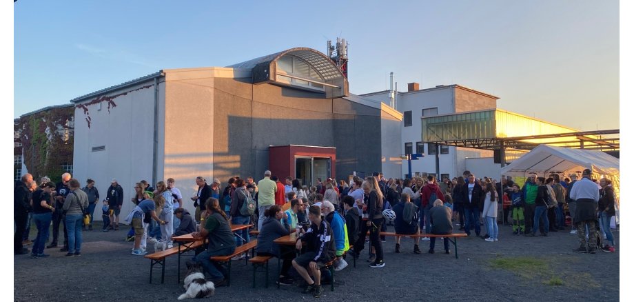 Viele Menschen stehen draußen vor einem Gebäude