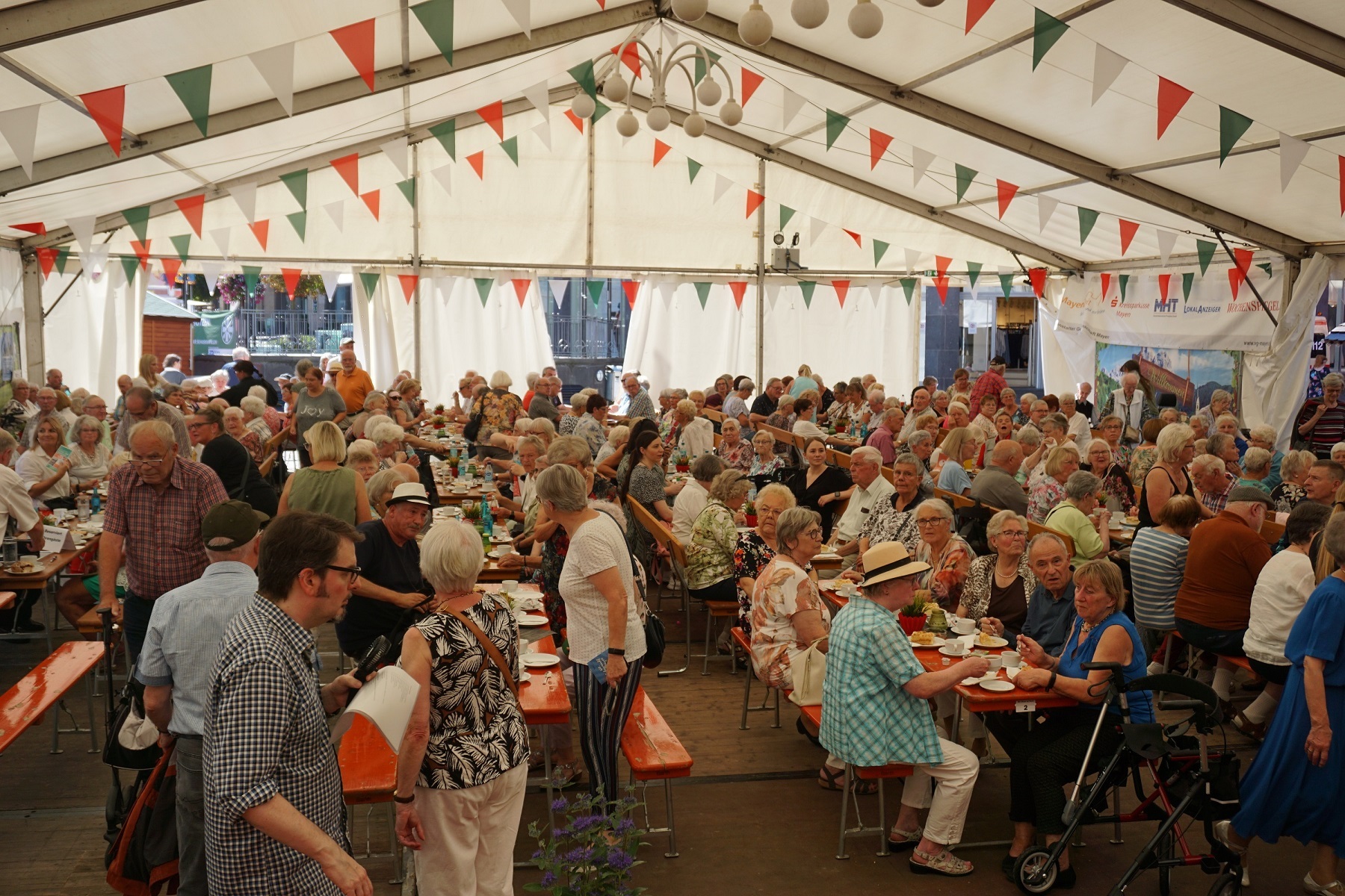 Viele Seniorinnen und Senioren gemeinsam im Zelt beim Stein- und Burgfest